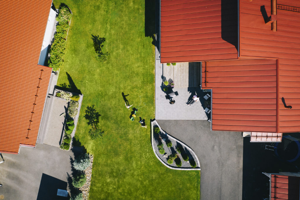 Omatkotitalon piha ja punaiset katot kuvattuna ylhäältä päin.