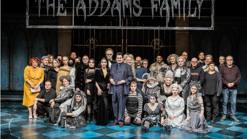 Addamsin perhe (The Addams Family) -musikaalin tekijäporukkaa lavalla. Näyttelijöillä on maskit ja puvut kuten vampyyyreillä.
