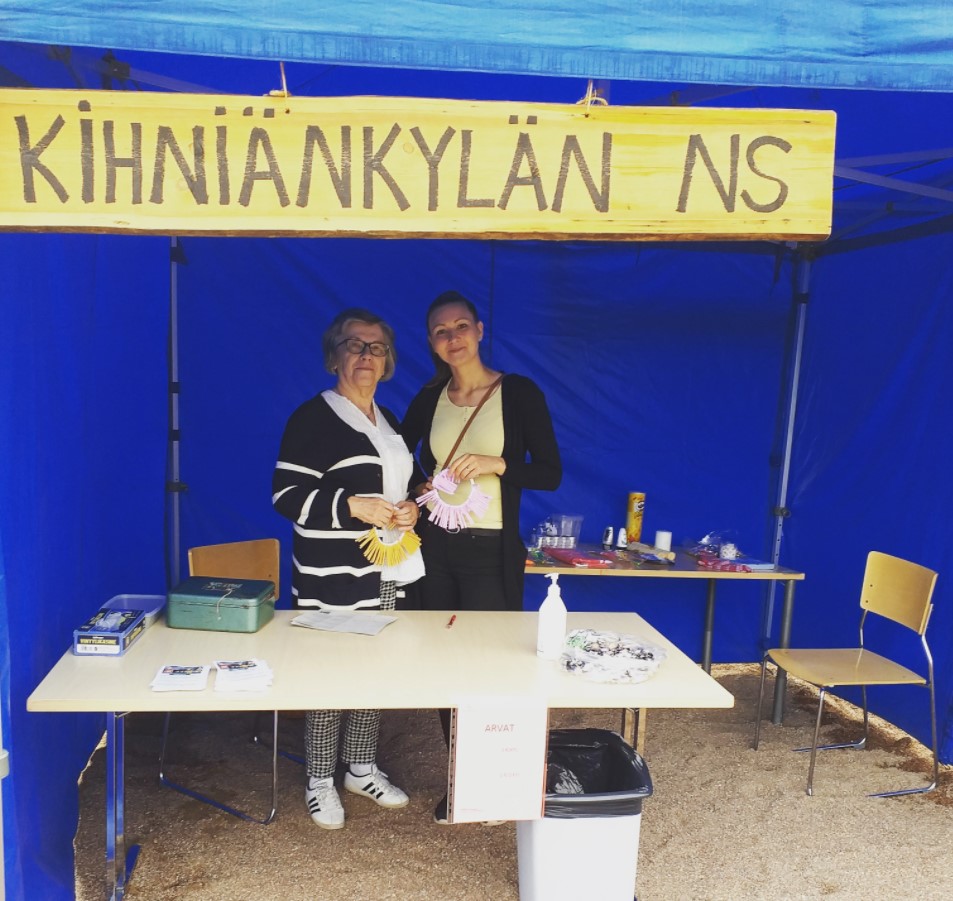 Kaksi naista ovat teltan sisällä myymässä arpoja.