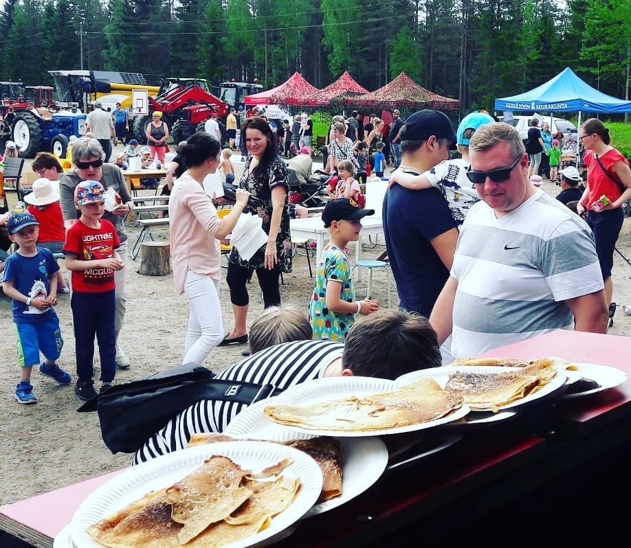 Etualalla on lautasia täynnä lettuja ja takana markkinatunnelmaa.