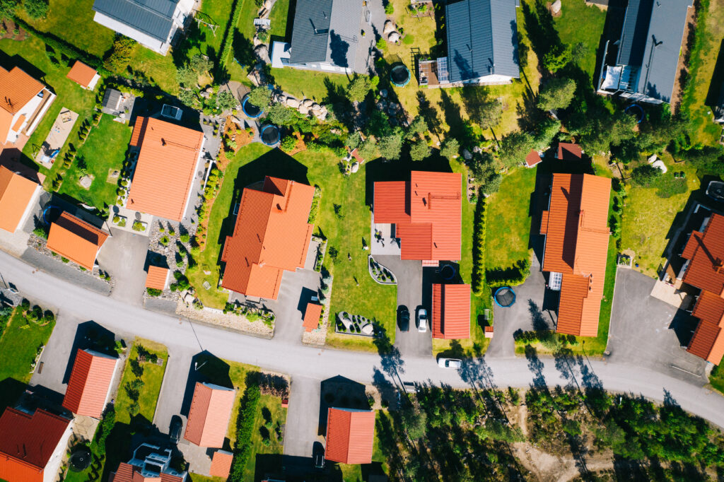 Asuntoalue, jossa puna- ja mustakattoisia omakotitaloja, ylhäältä päin kuvattuna.