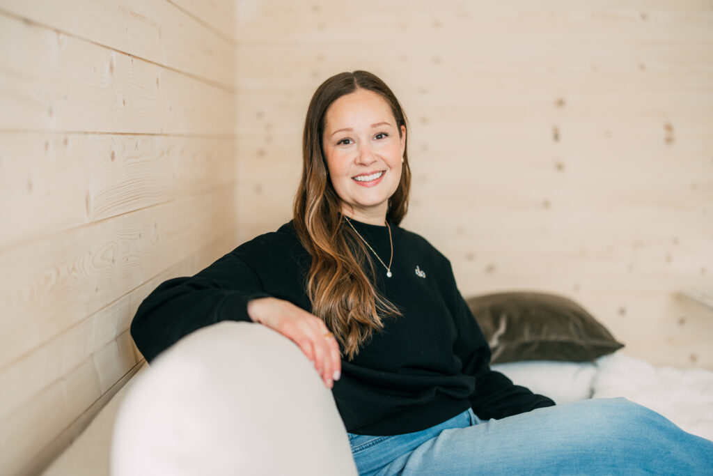 Nainen istuu sohvalla.