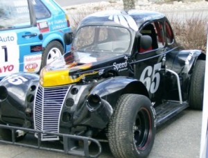 Musta kilpa-auto, jossa on numero 65.