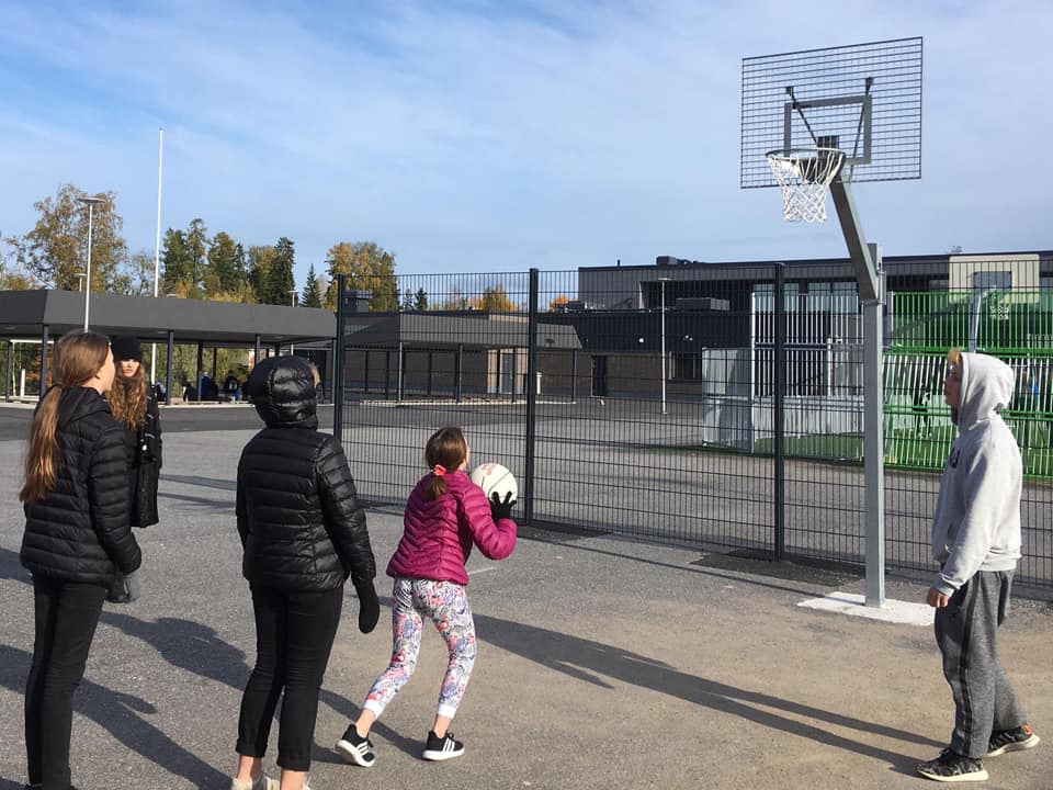 Viisi oppilasta pelaa Ylistaron yläkoulun pihassa koripalloa syksyllä.