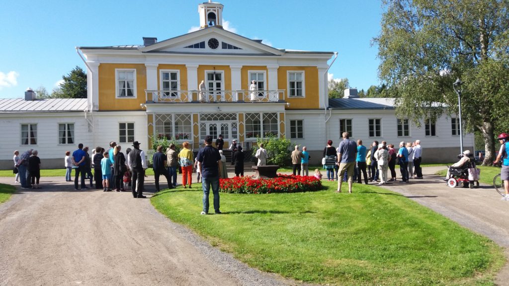 Väkeä kokoontuneena keltavalkoisen Törnävän kartanon päärakennuksen eteen