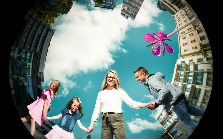 Kaksi aikuista ja kaksi lasta käsi kädessä.