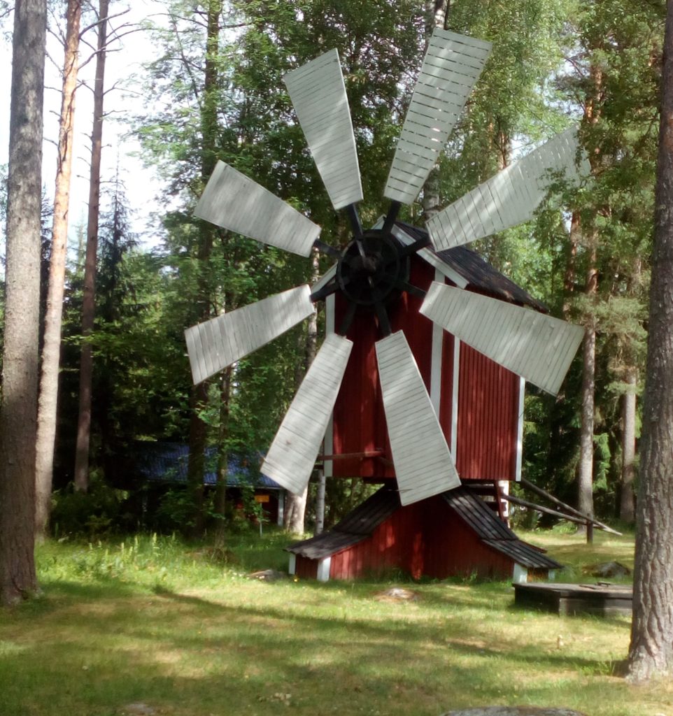 Punainen vanha tuulimylly, jossa kahdeksan valkoista siipeä