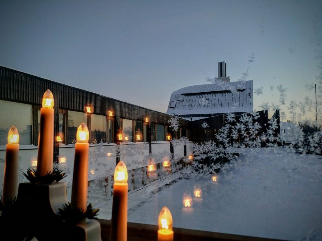 Kuurainen ikkuna jossa joulukynttilät