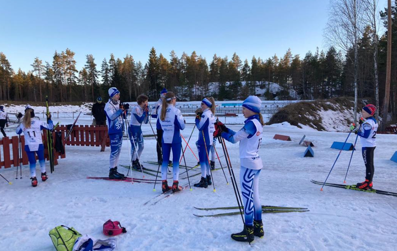 Nuoria kilpahiihtäjiä kilpailupaikalla hiihtovarusteissa.