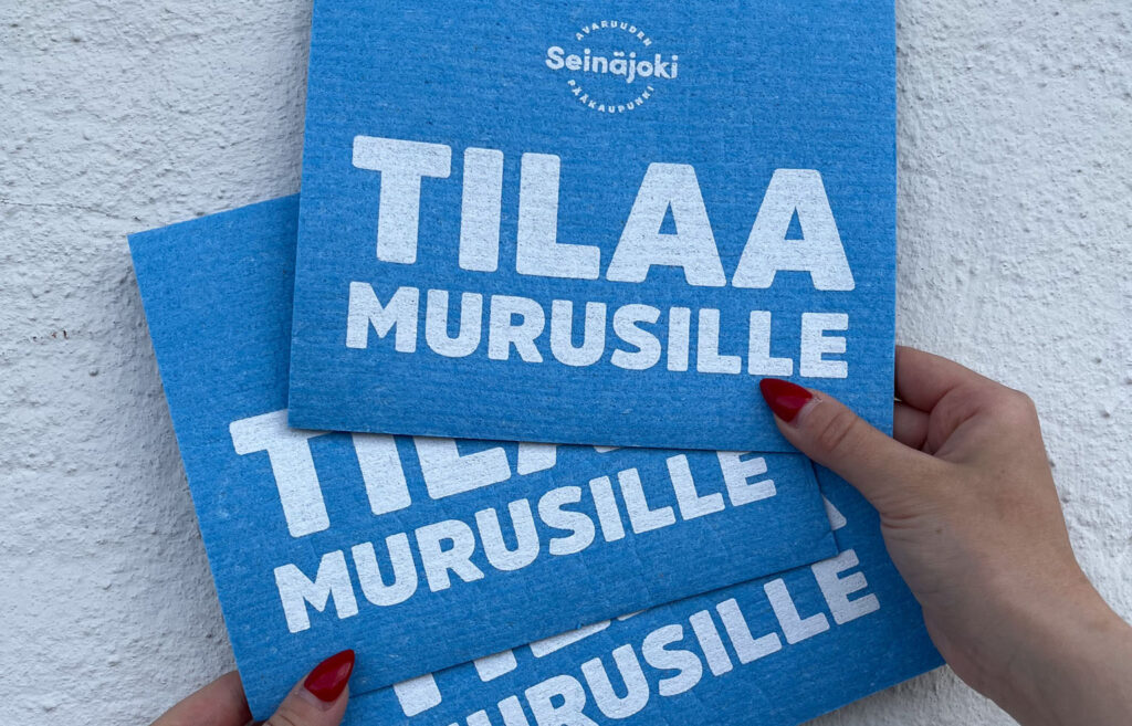 Kolme sinistä tiskirättiä, joissa valkoisella teksti Tilaa murusille.