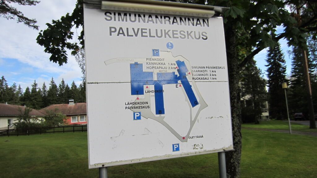 Palvelukeskuksen opastekyltti, jossa karttakuva rakennuksesta ja pysäköintipaikoista. 