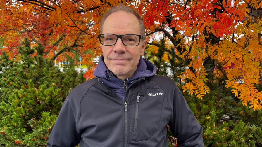 Mies seisoo syksyisen puun alla