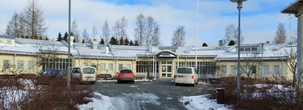 Koivukaaren palvelukeskus. Vaaleankeltainen rakennus, jossa on siniharmaa katto. Talvinen kuva.