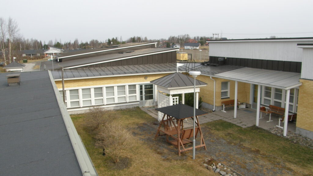 Västinkartano kuvattuna katolta. Rakennuksessa on keltaiset seinät ja valkoiset ikkunapuitteet.