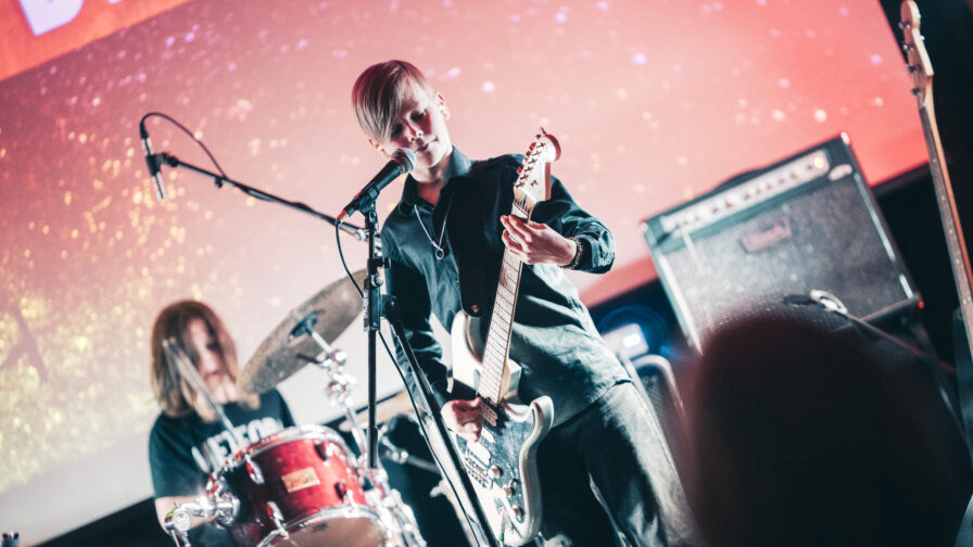 Laulaja-kitaristi ja rumpali esiintyy lavalla.