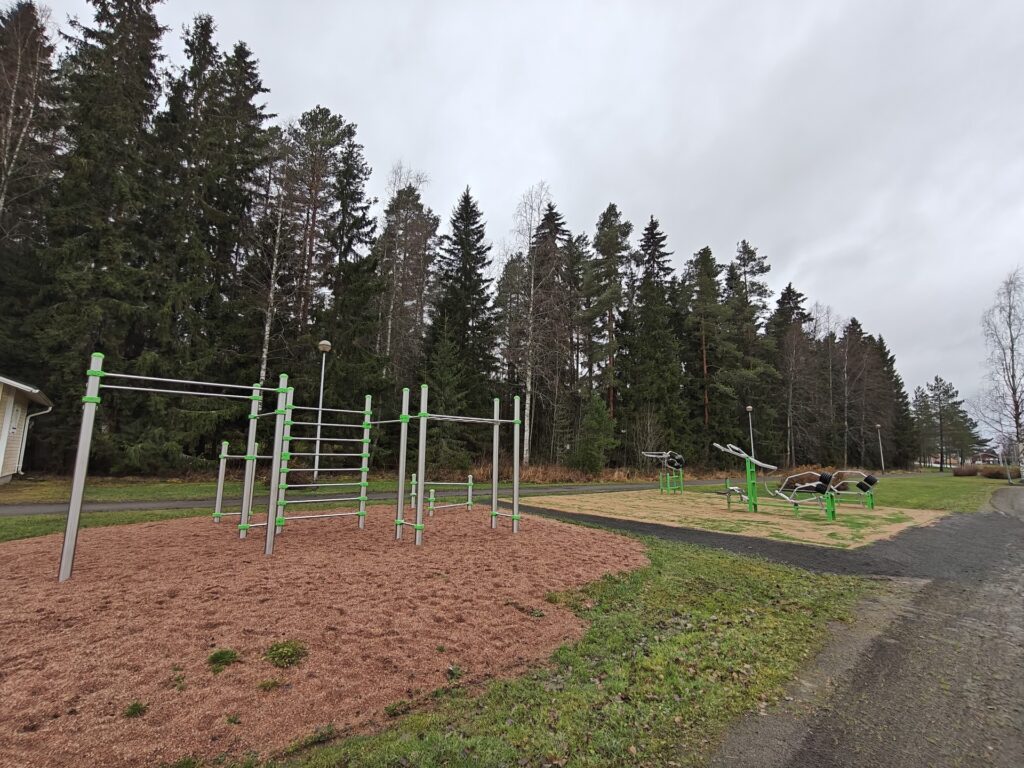 Ulkokuntosalilaitteita. Taustalla metsää.