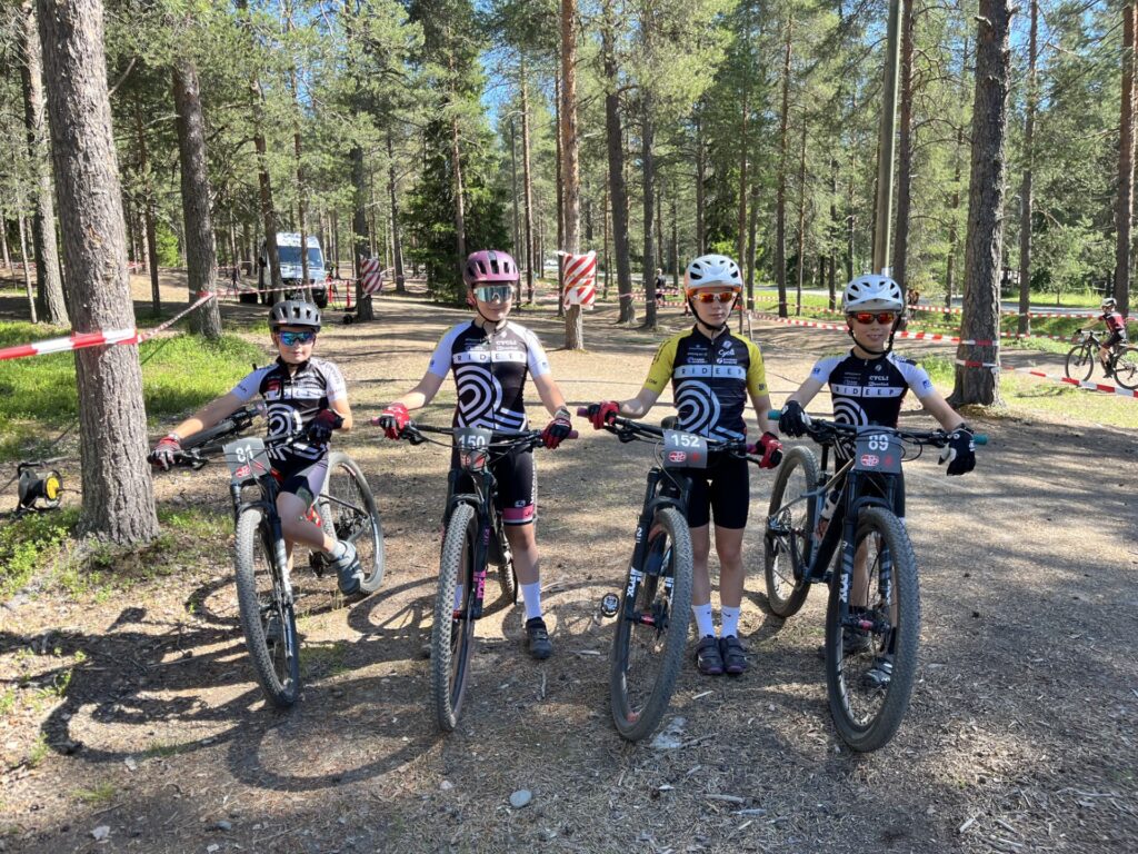 Neljä nuorta pyörälijää maastoajon kilpailualueella mtsätiellä.