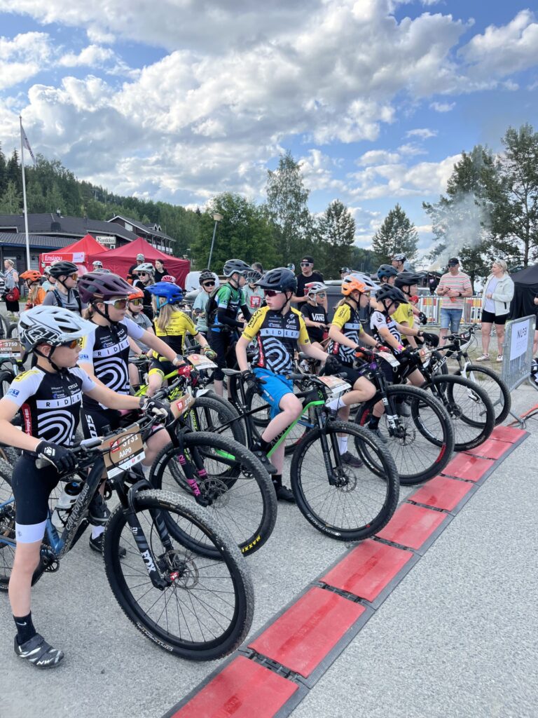 Nuoria maastopyörälijöitä odottamassa lähtöviivalla.