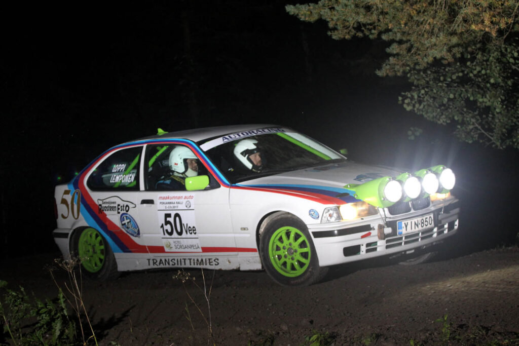 Ralliauto pimeällä tiellä.