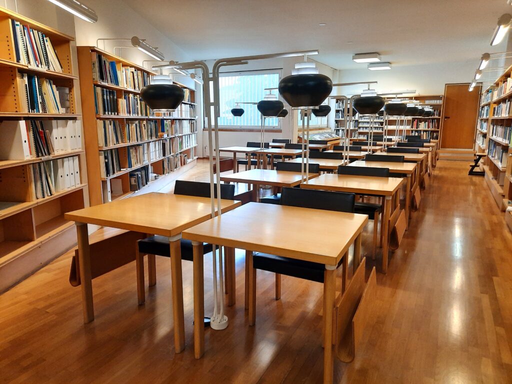 Lukupöytiä ja kirjahyllyjä.