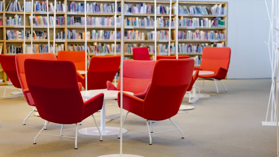 Kirjahyllyjä ja punaisia nojatuoleja