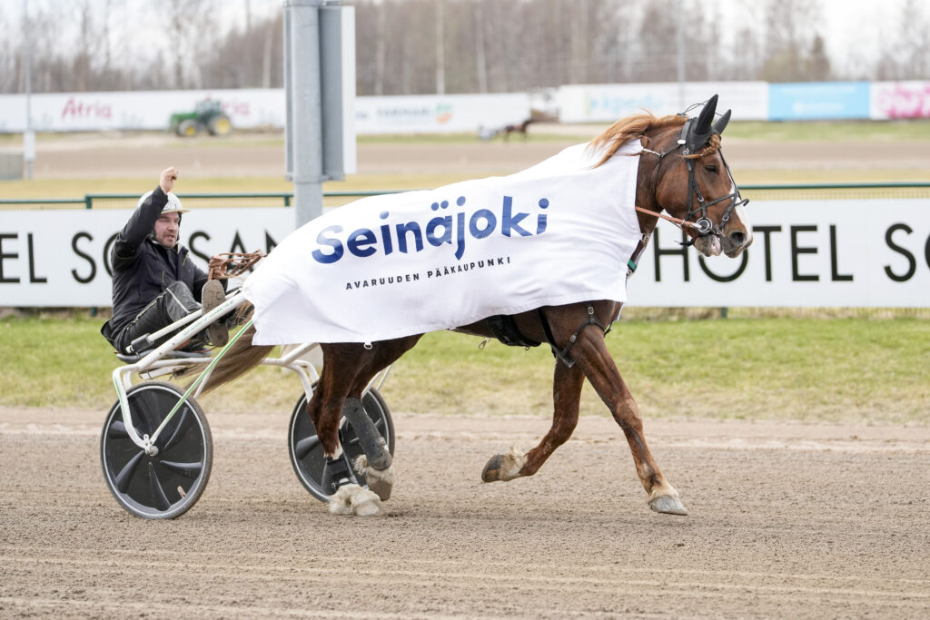 Ravihevonen radalla päällään valkoinen loimi, jossa teksti Seinäjoki avaruuden pääkaupunki.