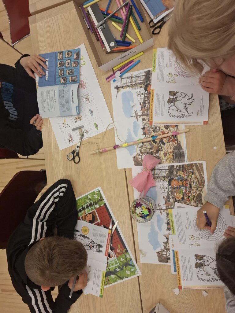 Lapsia pöydän ääressä tekemässä tehtäviä.