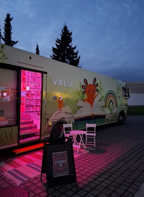 Kirjastoauton avoin ovi, josta hehkuu punaista valoa.